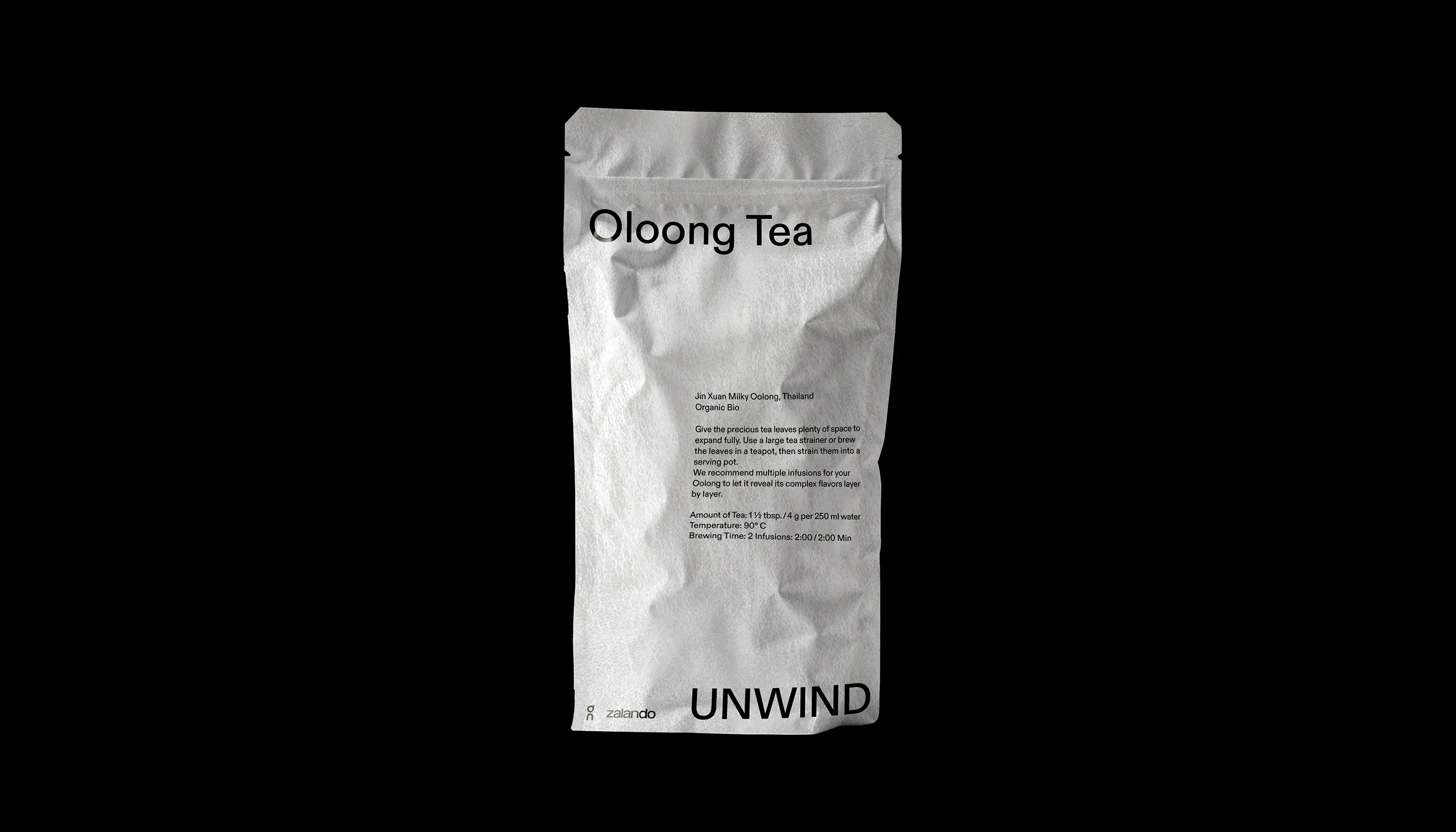 White foil tea package labeled Oolong Tea with brewing instructions and 'UNWIND' branding on the front.