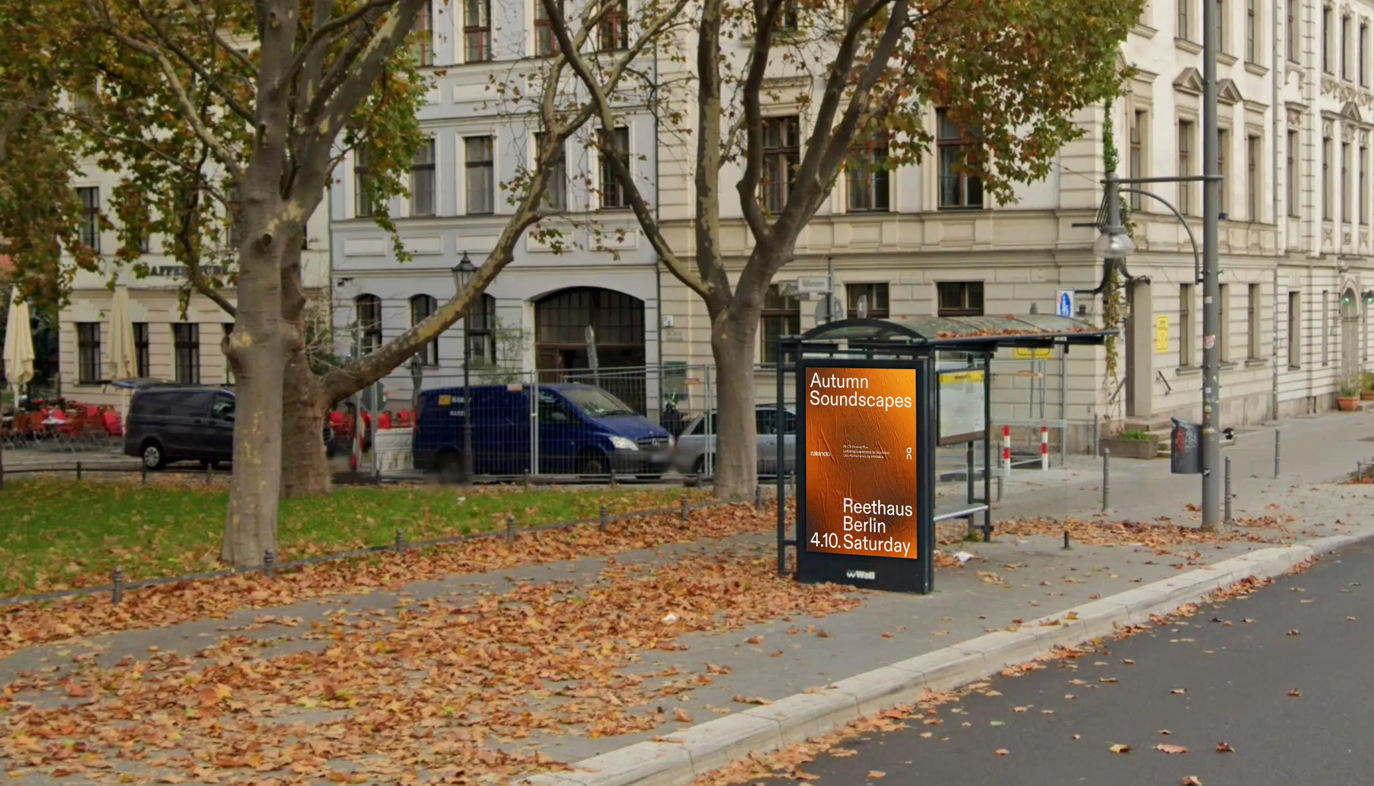 Bus stop in a city street with autumn leaves scattered on the pavement and a vibrant orange poster advertising 'Autumn Soundscapes' event in Berlin.